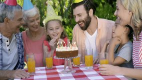 Birthday girl blowing out cake candles causing gold confetti falling for event planning. Family, celebration, outdoor, festive, joyful, generational, vibrant - Powered by Shutterstock - Get 15% off with code: PIKWIZARD15