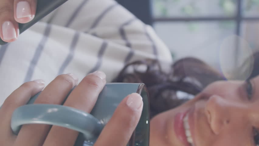 Animation of data processing over woman using smartphone and drinkin tes at home. global connection and digital interface concept digitally generated video.