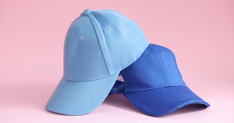Woman taking light blue baseball cap on pink background, closeup