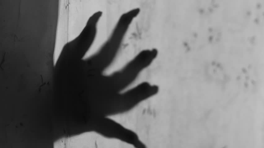 Creepy shadow of hands with long nails appearing on a curtain, evoking fear, mystery, and supernatural horror in a chilling ghost scene concept.