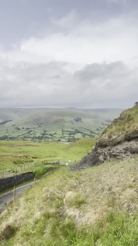 Breathtaking summer view from the highest hill in the northern English countryside. Rolling green hills stretch into the distance under a soft, cloudy sky. Peaceful and panoramic landscape footage.