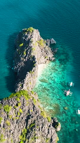 Drone view of Twin Rocks in Miniloc Island. Boats over the sea. El Nido, Philippines. Palawan. Vertical view.