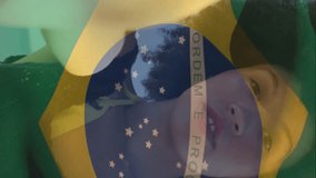 Animation of flag of brazil waving over woman talking selfie video with camera at beach. Digital composite, multiple exposure, freedom, government, patriotism and technology concept. - Powered by Shutterstock - Get 15% off with code: PIKWIZARD15
