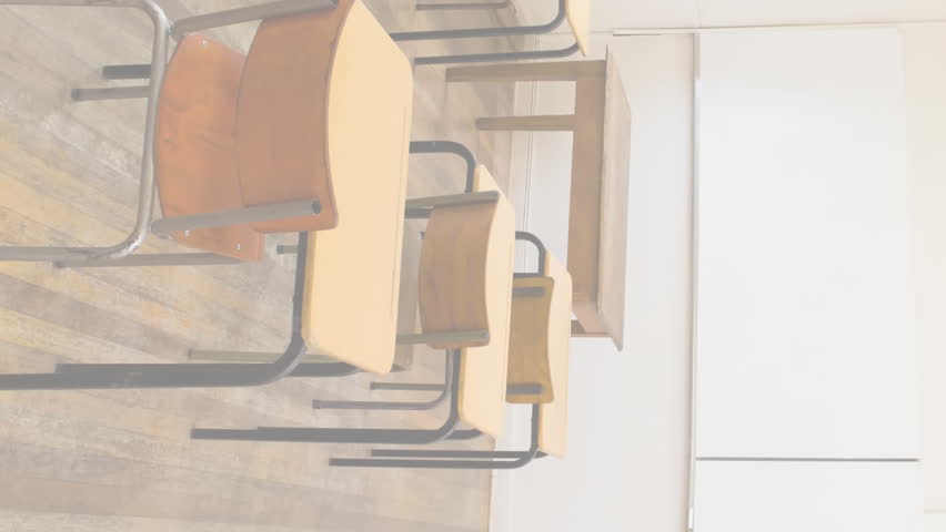 Multiple book icons falling against view of empty classroom at school. back to school and education concept