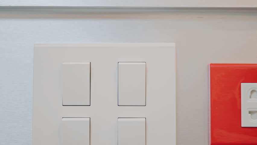 Female finger pushing for turn on light switch on white wall at home room. Woman hand turn off lighting Switch. Energy Saving, energy power control, electrical, eco environment, and lifestyle concept