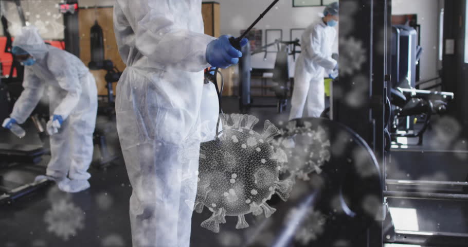 Camera panning to man misting gym machines while team wiping benches ensuring safe surfaces. Professional cleaning, hygiene, disinfection, sanitation, safety, industrial design, wellness