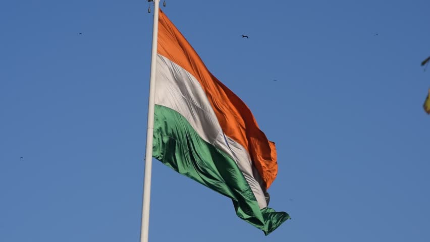 India flag flying high at Connaught Place with pride with plain white background, India flag fluttering, Indian Flag on Independence Day and Republic Day of India, tilt up shot, Har Ghar Tiranga