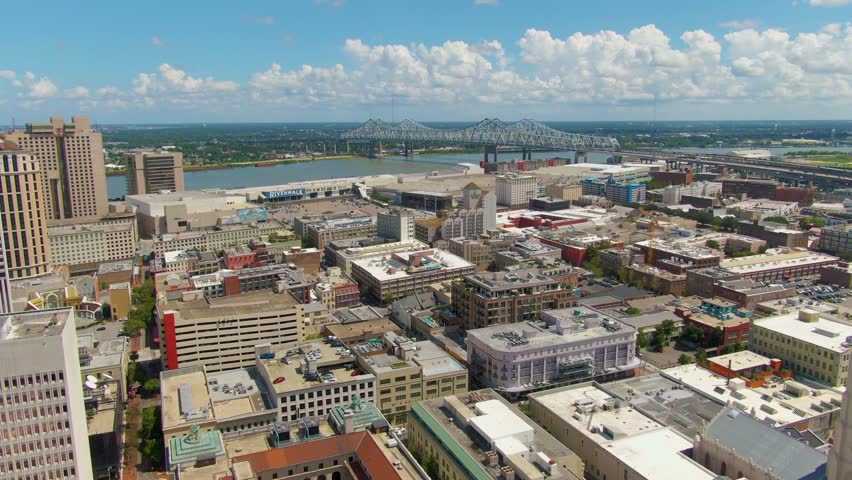 A still drone shot of the Central Business District of New Orleans, Louisiana, including the central city connection bridge, buildings, and Algiers Point across the Mississippi River.