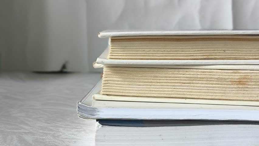 Female hands take an old book from a stack of books lying on the table. Learning. School textbooks.