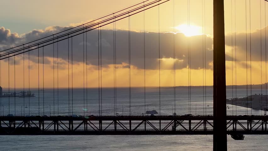 Sunset Sky Over 25 Of April Bridge At Lisbon In Lisbon District Portugal. Sunset Downtown. Freeway Road Landscape. 25 Of April Bridge At Lisbon In Portugal. Railroad Scenery.