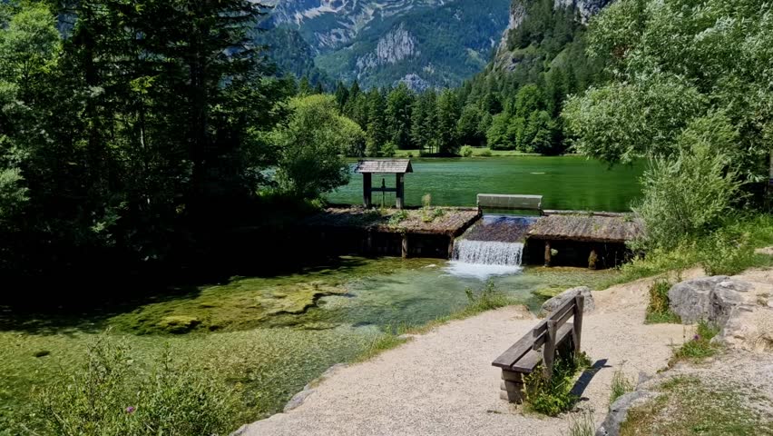 The sluice of the lake in the high mountains is used to float logs. Beautiful scenery with rocky mountain peaks. Translucent karst water