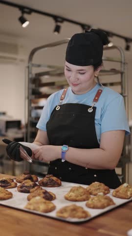 Baker adding chocolate on cookies in a professional kitchen
