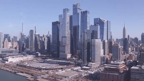 Drone flies past modern glass towers of Hudson Yards with the Empire State Building and Midtown Manhattan skyline in the background. - Powered by Shutterstock - Get 15% off with code: PIKWIZARD15