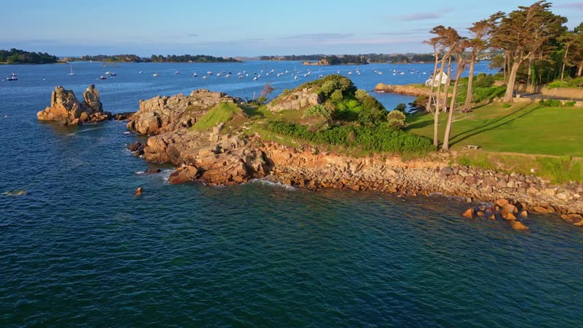Rocky coast and harbor at Port Blanc, Plage Le Voleur, golden hour, Brittany, France. Aerial drone low-altitude