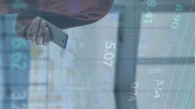 Animation of stock market data processing against caucasian man smiling while using smartphone. Global economy and business data technology concept - Powered by Shutterstock - Get 15% off with code: PIKWIZARD15