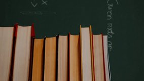 Digital composite of a pile of books while mathematical equations and graphs written in a green background moves - Powered by Shutterstock - Get 15% off with code: PIKWIZARD15