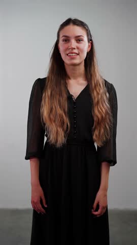 A cheerful young Caucasian woman smiles sweetly and giggles while speaking to the camera, creating an engaging and friendly vlog intro