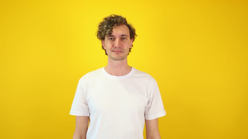 Serene man takes a deep breath in a lotus yoga pose against a yellow studio backdrop perfect for wellness campaigns, burnout prevention, corporate mindfulness, meditation apps, and World Yoga Day.