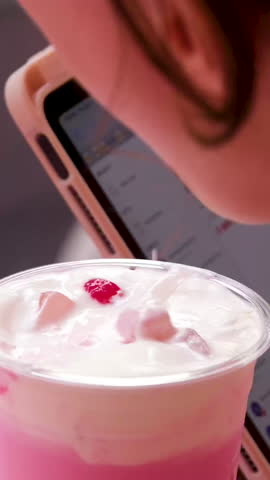 Fruit milk cocktail rotating moving top view. Pink lactose beverage swirling in slow motion. Creamy dairy liquid vortex with waves closeup. Calcium milkshake making funnel. Drink preparing concept