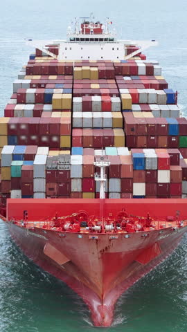 Aerial of cargo ship carrying container  for export cargo from cargo yard port to other ocean concept smart freight shipping ship front view