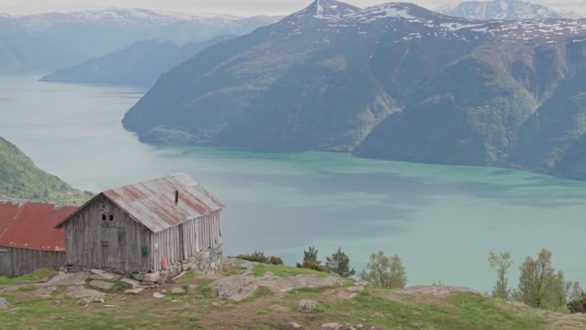 Epic mountain biking adventure above the fjords near Sogndal, Norway. Rider tackles rugged trails surrounded by dramatic cliffs, lush green hills, and stunning Nordic scenery.