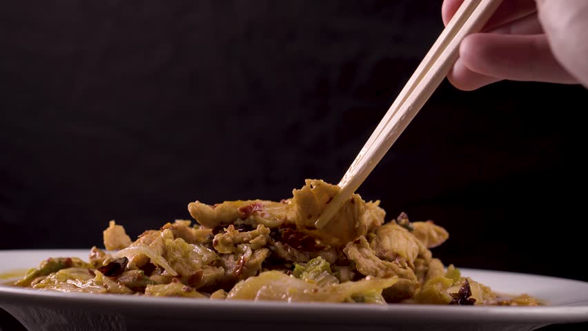 Sichuan fried chicken with vegetables on a dark background. Chinese cuisine. Food concept