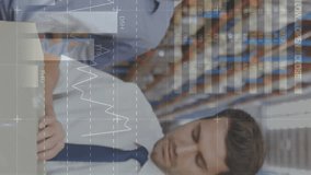 Close up of two Caucasian male warehouse managers. One of them is opening a package while the other spectates from behind. Digital animation graphs and statistics are running int the foreground - Powered by Shutterstock - Get 15% off with code: PIKWIZARD15