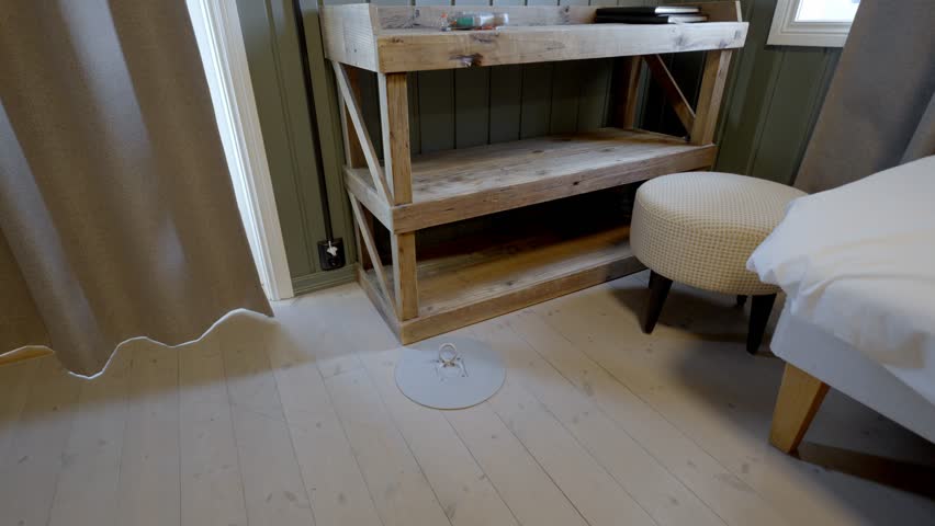 Man opens floor hatch and places hand line with rubber lures inside Lofoten hotel room