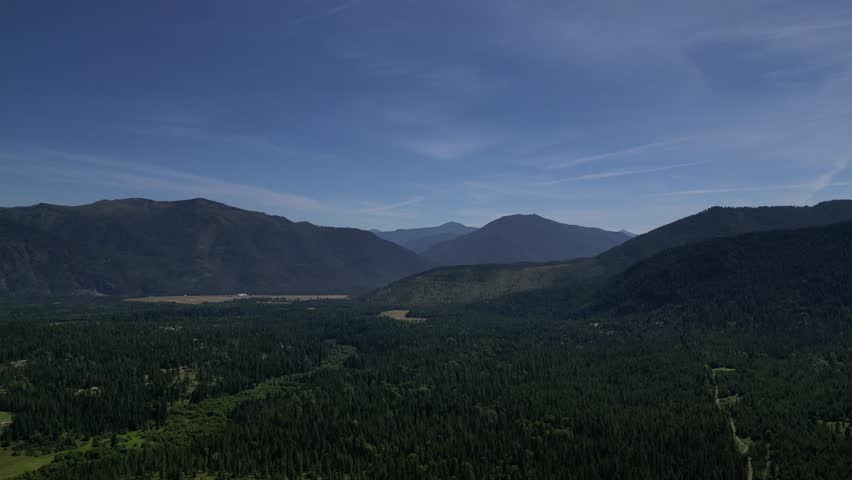 Aerial drone shot gliding over Montana’s wild terrain—towering pine trees, vast mountain ranges, and untouched natural beauty. Ideal for adventure, travel, and scenic landscape projects.