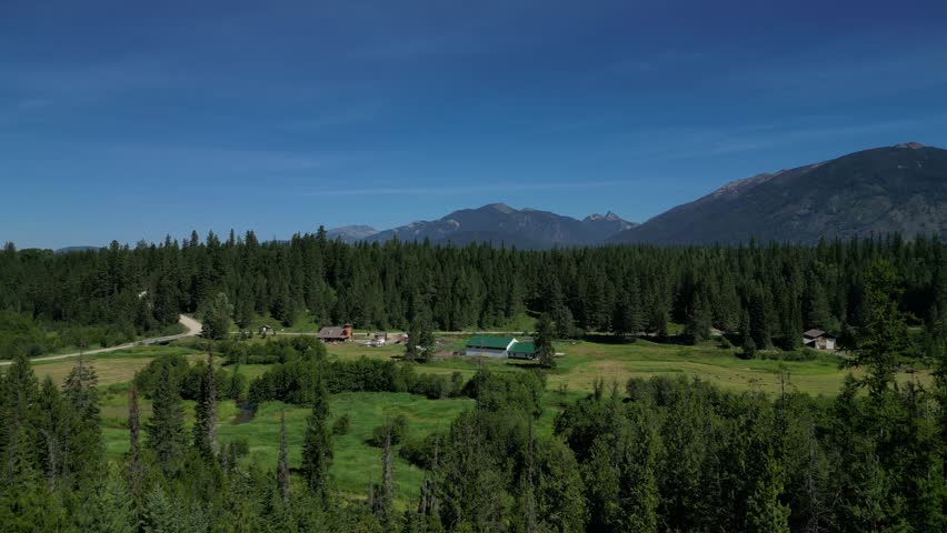 Aerial drone footage flying over Montana’s forested mountains and open meadows. Scenic summer landscape ideal for travel, adventure, and nature themes