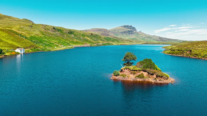 This breathtaking aerial perspective captures a tranquil island adorned with greenery, surrounded by calm blue waters in the picturesque landscape of Scotland.