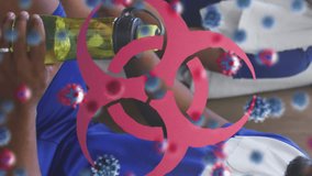 Animation of virus cells and biohazard symbol over group of football players in changing room. global sport during covid 19 pandemic concept digitally generated video. - Powered by Shutterstock - Get 15% off with code: PIKWIZARD15