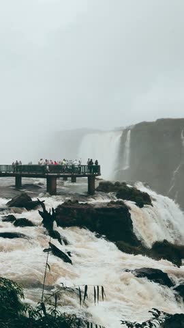 Tourists admiring the breathtaking Iguazu Falls from the main observation deck