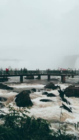 Tourists admiring the breathtaking Iguazu Falls from the main observation deck