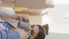 Animation of silver house key and key fob over diverse couple drinking tea at new home. House, home, property, ownership and lifestyle concept digitally generated video. - Powered by Shutterstock - Get 15% off with code: PIKWIZARD15