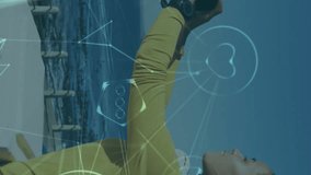 Animation of technological icons over woman taking a selfie on promenade by the sea. Digital interface global sport and performance concept digitallygenerated video. - Powered by Shutterstock - Get 15% off with code: PIKWIZARD15
