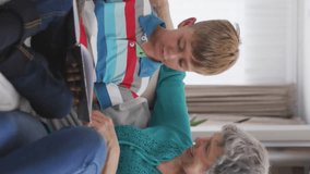 Animation of heart icons over caucasian grandmother and grandson reading book in livin groom. family life, childhood, love and care concept digitally generated video. - Powered by Shutterstock - Get 15% off with code: PIKWIZARD15