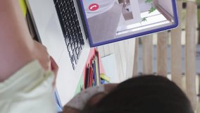 Animation of heart icons over girl in face mask using laptop on video call. Digital interface global covid 19 pandemic and communication concept digitally generated video. - Powered by Shutterstock - Get 15% off with code: PIKWIZARD15