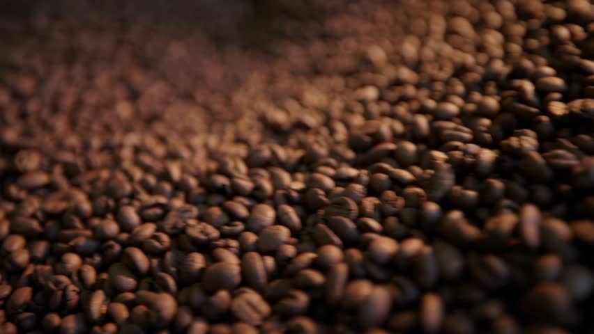 Smooth coffee roasting process highlighting beans and roasting equipment movement.