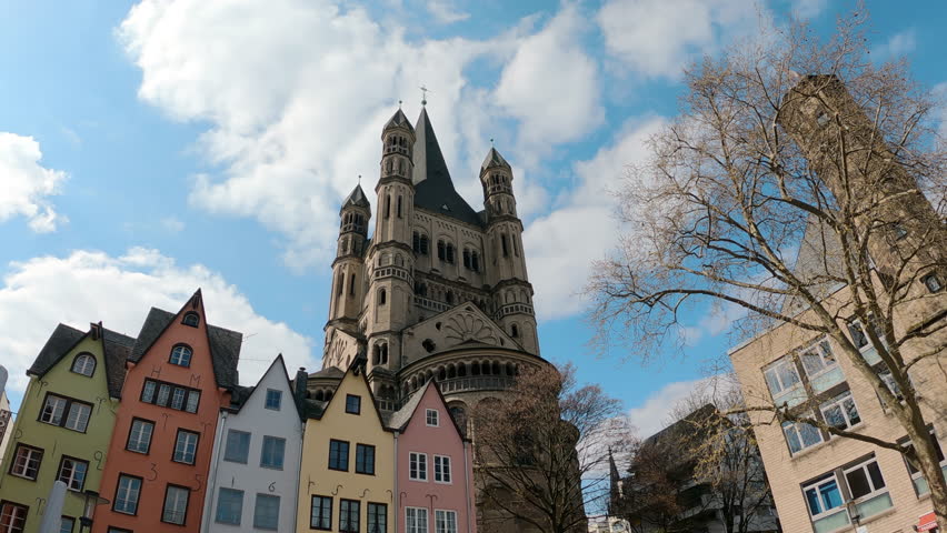This iconic Cologne view features Great Saint Martin Church, colorful buildings, and a clear sky