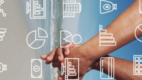 Animation of multiple icons over midsection of diverse couple holding hands and walking on beach. Digital composite, multiple exposure, report, business, banking, holiday, love and togetherness. - Powered by Shutterstock - Get 15% off with code: PIKWIZARD15