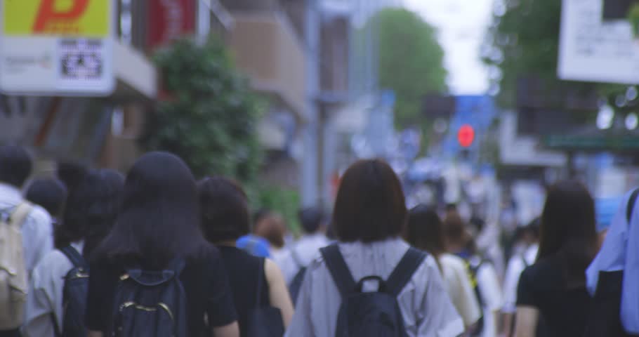 A slow motion of walking commuters on the city street in Tokyo telephoto shot