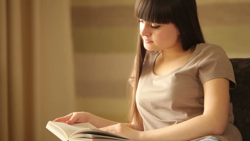 Young woman reading a book and smiling
