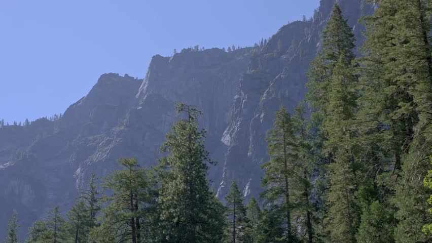A 4K static frame shows Yosemite’s jagged granite cliff rising straight up, all sharp ridges and deep cracks etched in gray stone.