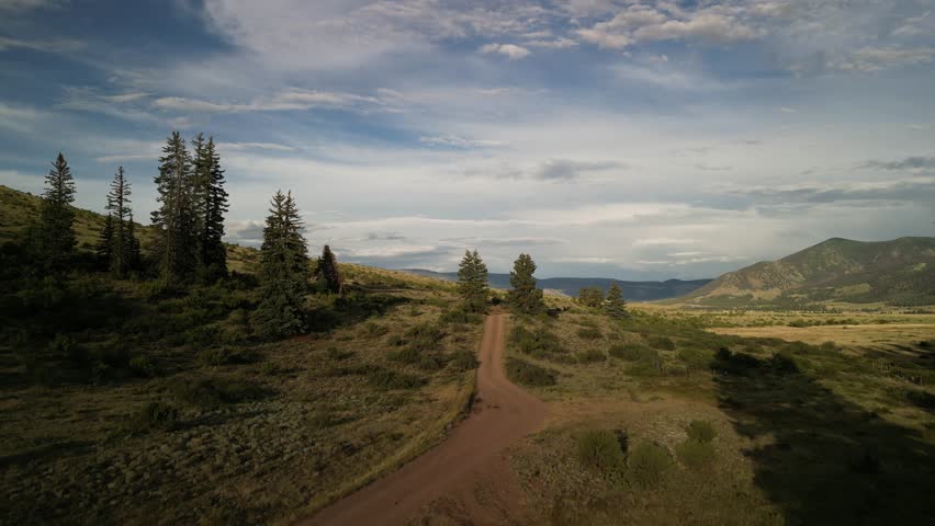 Sunset summer aerial over grassy hills in Creede Colorado in San Juan Mountains