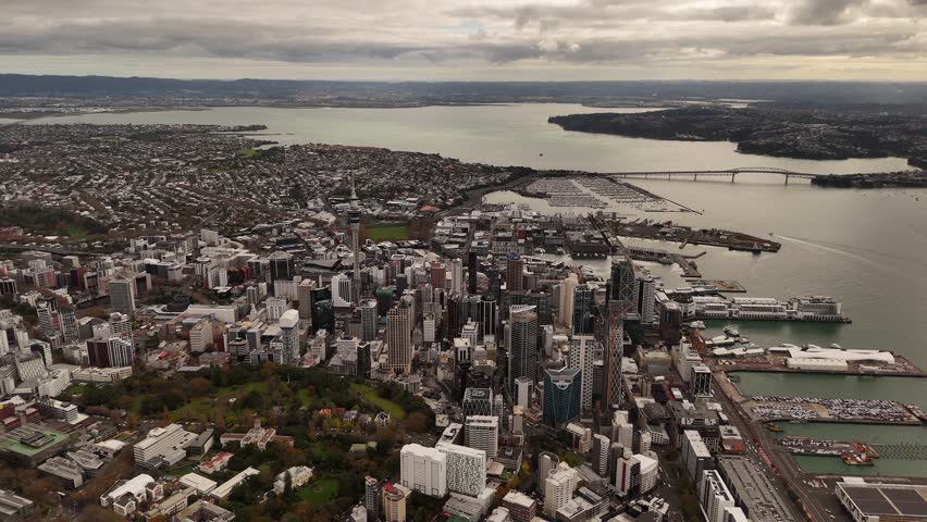 Vast 4K 60fps high-altitude panoramic view of the Auckland region. This epic aerial shot captures the city skyline, dual harbours, and the unique volcanic landscape from a bird