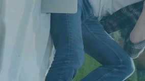 Animation of network of connections with icons over caucasian man using laptop in park. Social media, nature and digital interface concept digitally generated video. - Powered by Shutterstock - Get 15% off with code: PIKWIZARD15