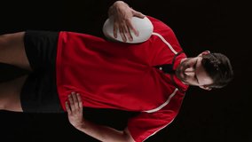 Animation of a young Caucasian male rugby player looking to camera and holding a ball in his hand while colourful powder falls against a black background 4k - Powered by Shutterstock - Get 15% off with code: PIKWIZARD15