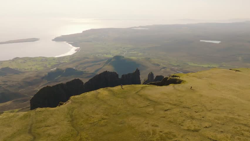 Aerial drone footage of the dramatic mountain landscapes on the Isle of Skye, Scotland. Sweeping panoramic views of majestic peaks, green valleys, and wild nature. Quiraing walk