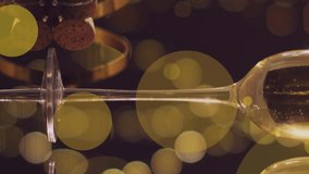 Animation of yellow spots of light over two glasses and bottle of new year champagne. New year, party, celebration and tradition concept digitally generated video. - Powered by Shutterstock - Get 15% off with code: PIKWIZARD15
